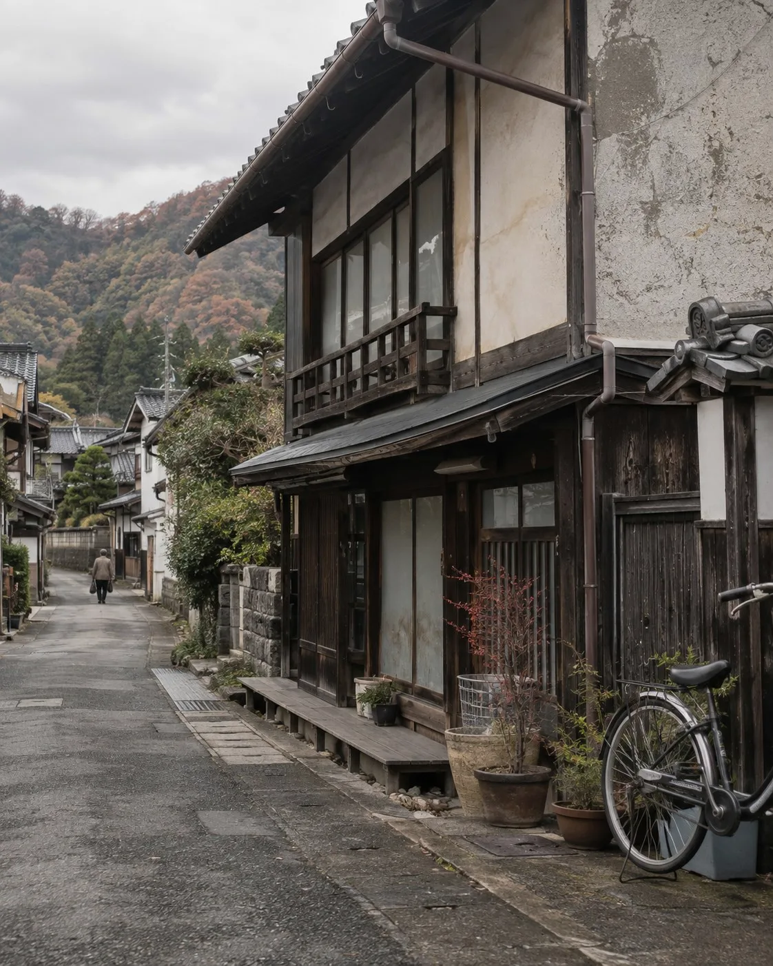 A modest timber building and planted doorway along a quiet Japanese town lane